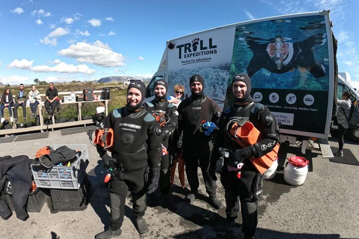 een groep mensen in wetsuits die voor een vrachtwagen staan