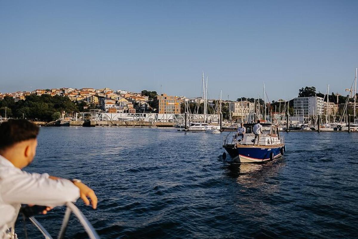moški, ki čez ograjo gleda na čoln v vodi