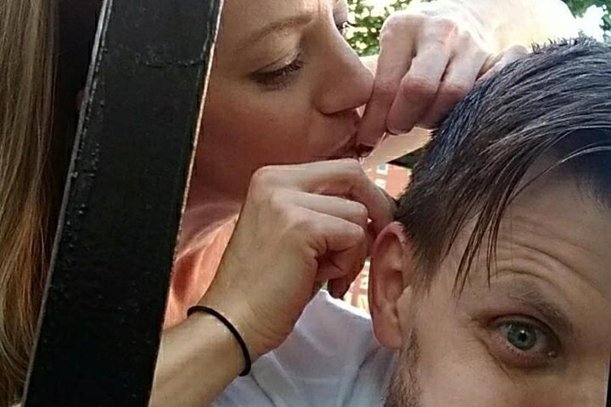 uma mulher está beijando a cabeça de um homem