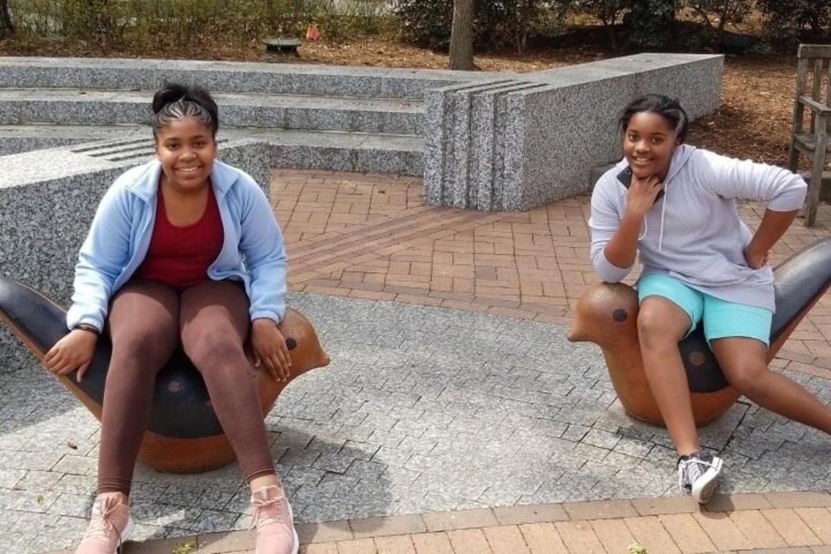 Dos niñas sentadas sobre caballos en un patio de recreo