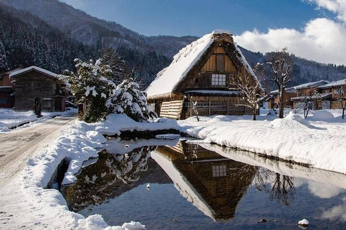 una baita nella neve accanto a un fiume