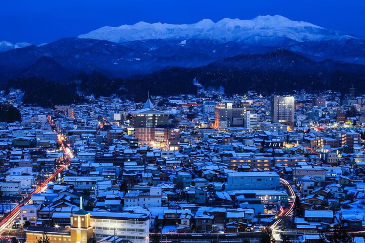 una città illuminata di notte con le montagne sullo sfondo
