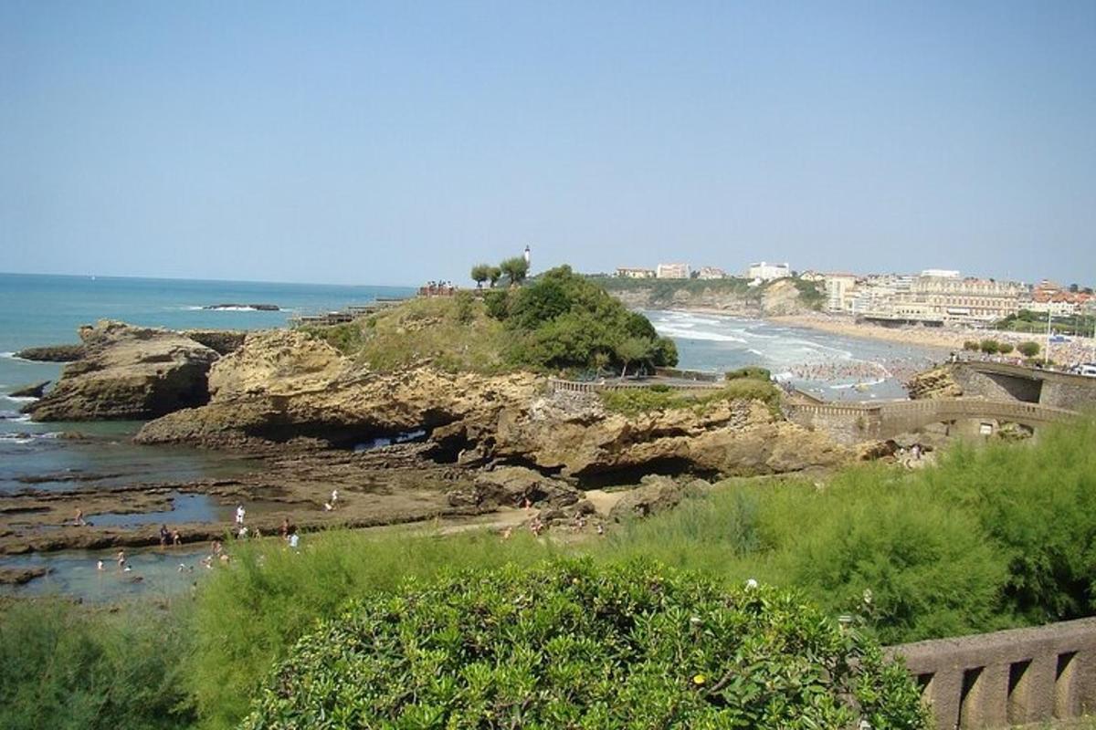 ชายหาดที่มีผู้คนอยู่บนโขดหินและมหาสมุทร