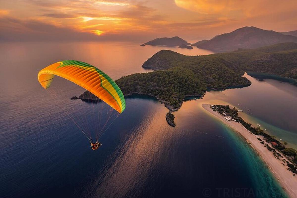 a person flying a parachute over a body of water