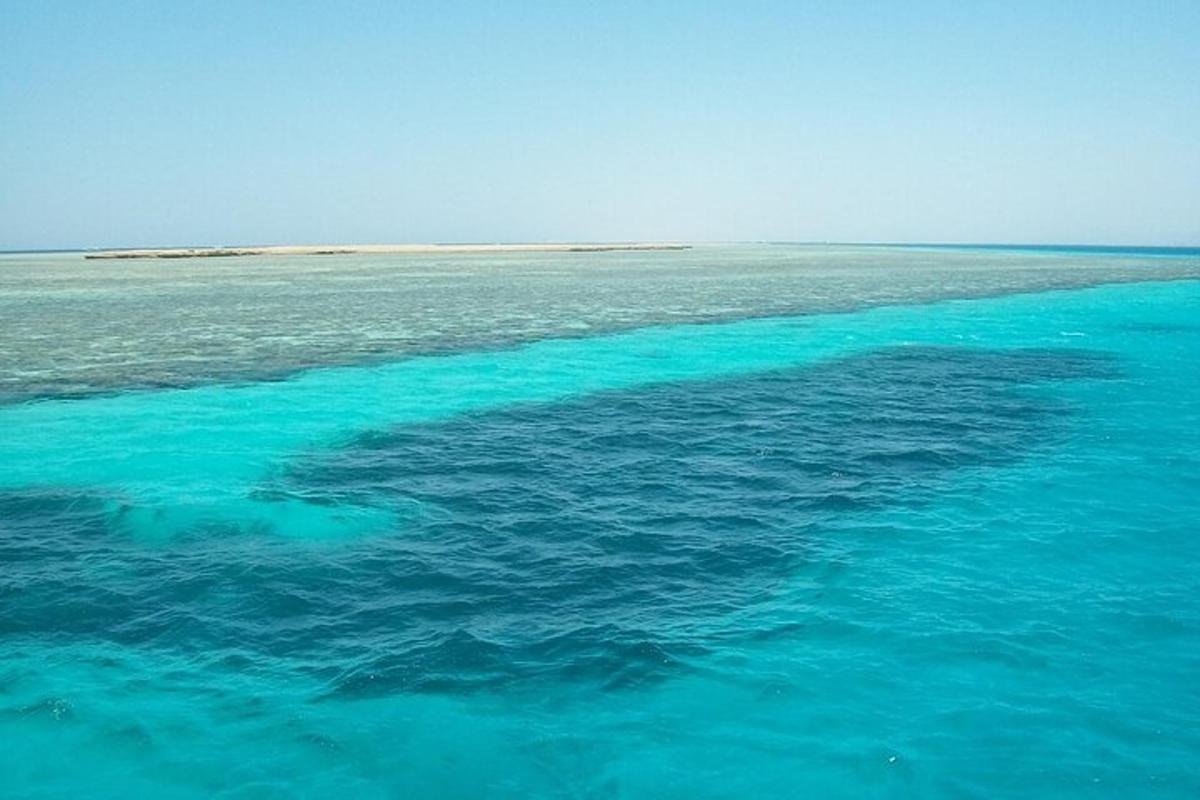 um grande corpo de água azul com uma ilha ao longe