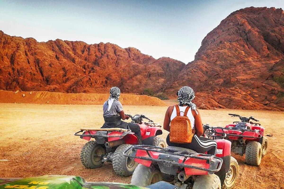 dua orang duduk di atv di padang pasir