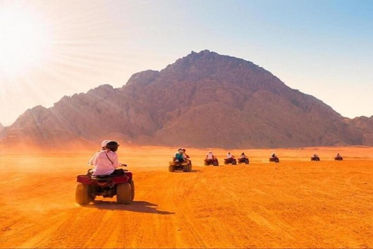 sekumpulan orang menunggang motosikal di padang pasir