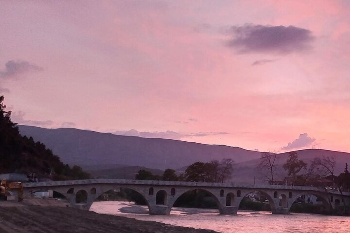 Μια γέφυρα πάνω από ένα ποτάμι με ένα ηλιοβασίλεμα