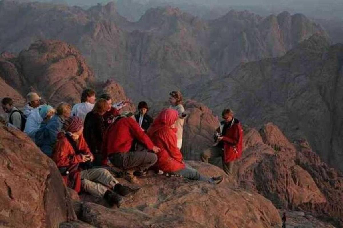un gruppo di persone sedute in cima a una montagna