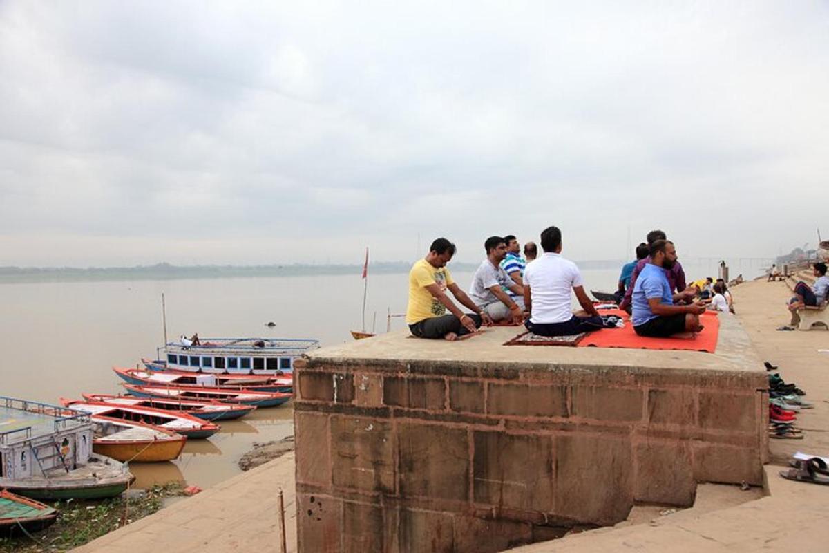 um grupo de pessoas sentadas em um muro perto da água