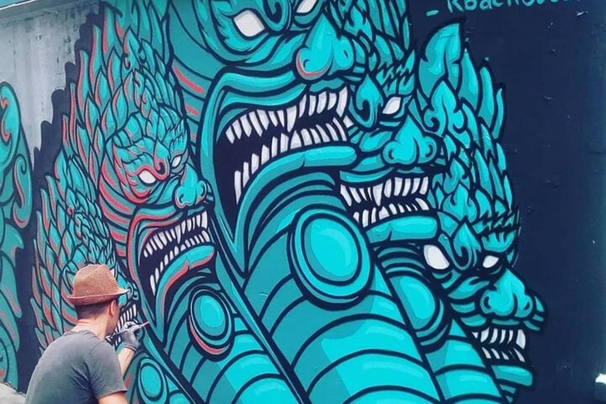 Un hombre parado frente a una pared con grafitis.