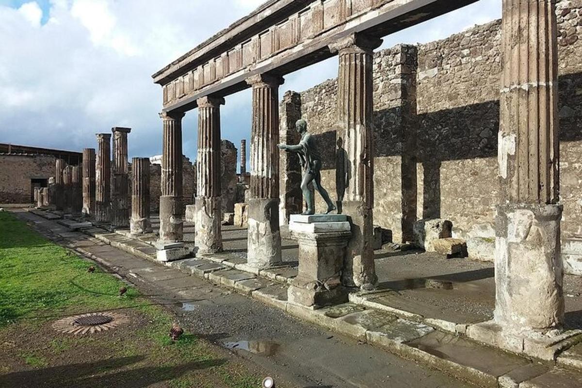 Una estatua de un hombre de pie en un edificio con columnas.
