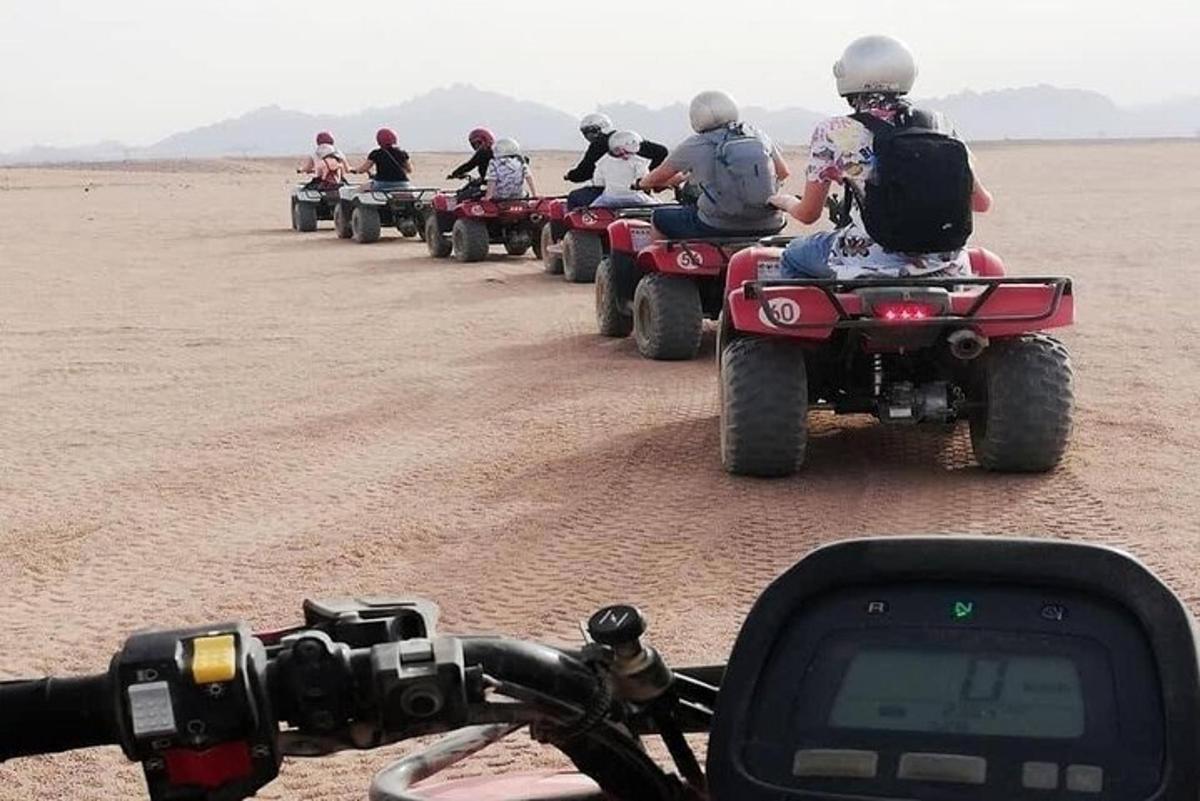 eine Gruppe von Leuten, die in der Wüste Geländefahrzeuge fahren