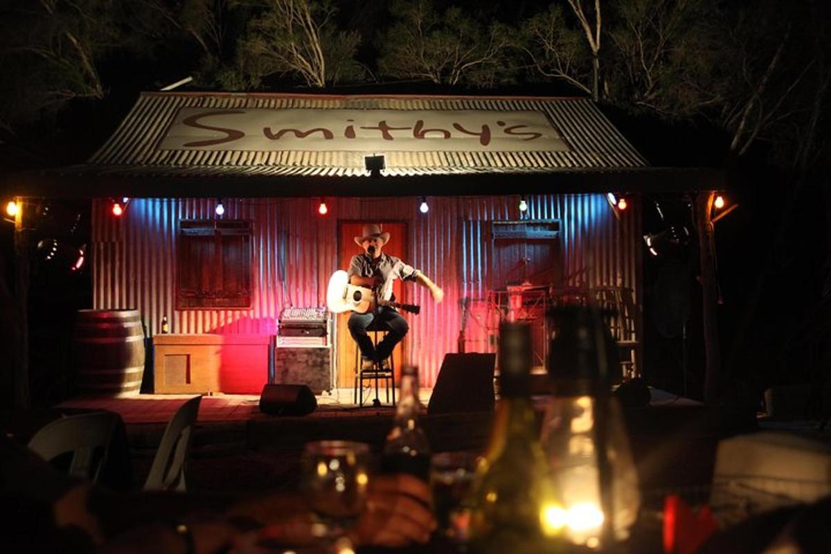a man sitting on a guitar on a stage