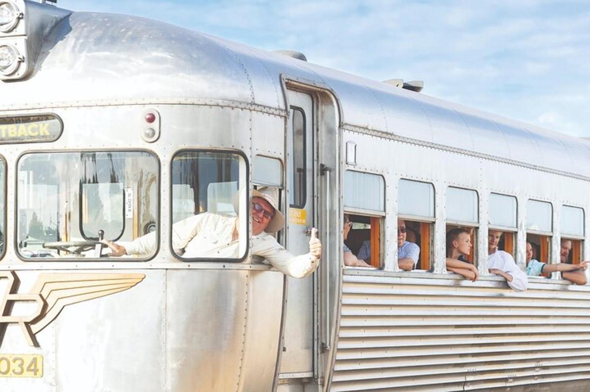 a man sticking his hand out of the window of a train