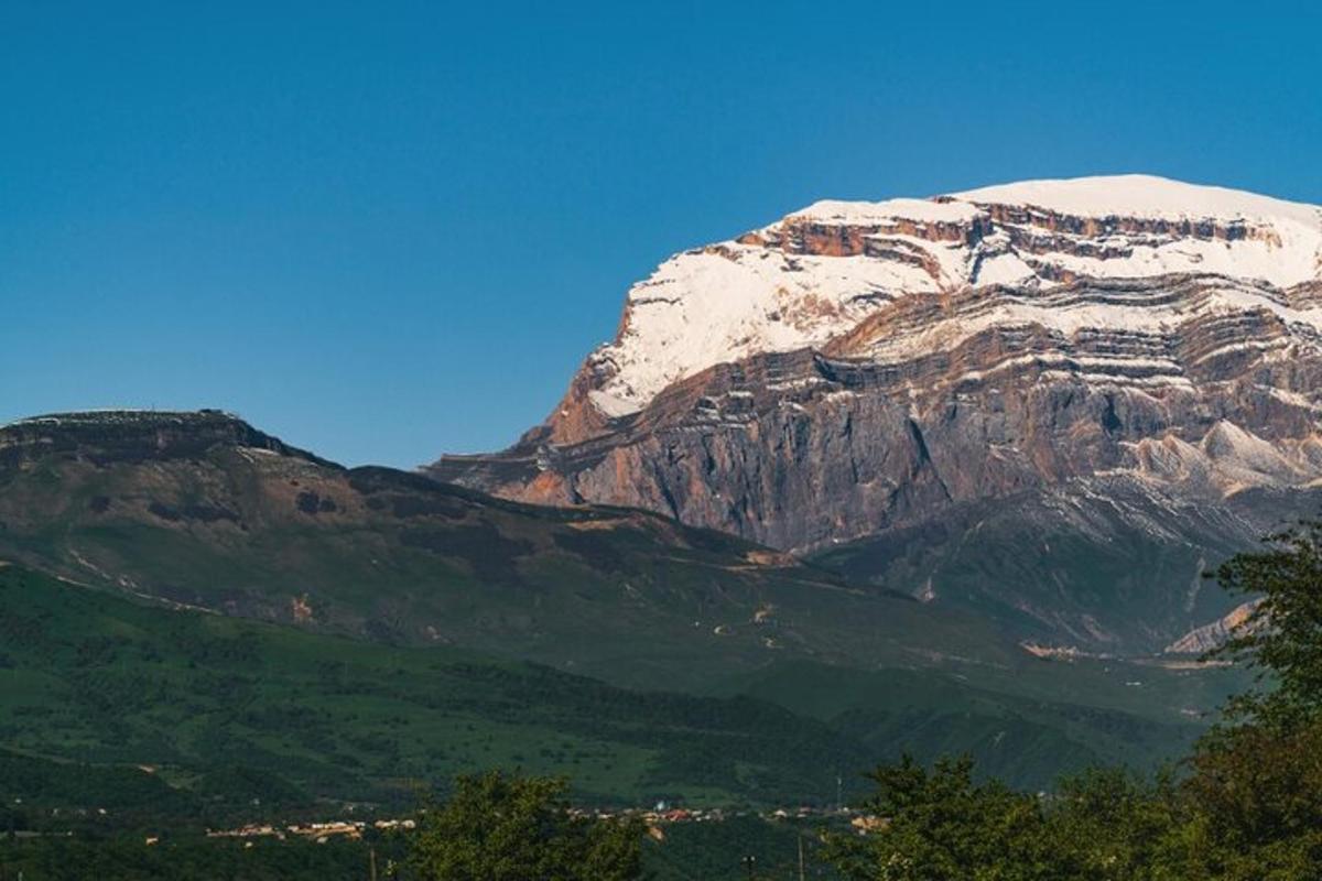a snow covered mountain with a town in front of it