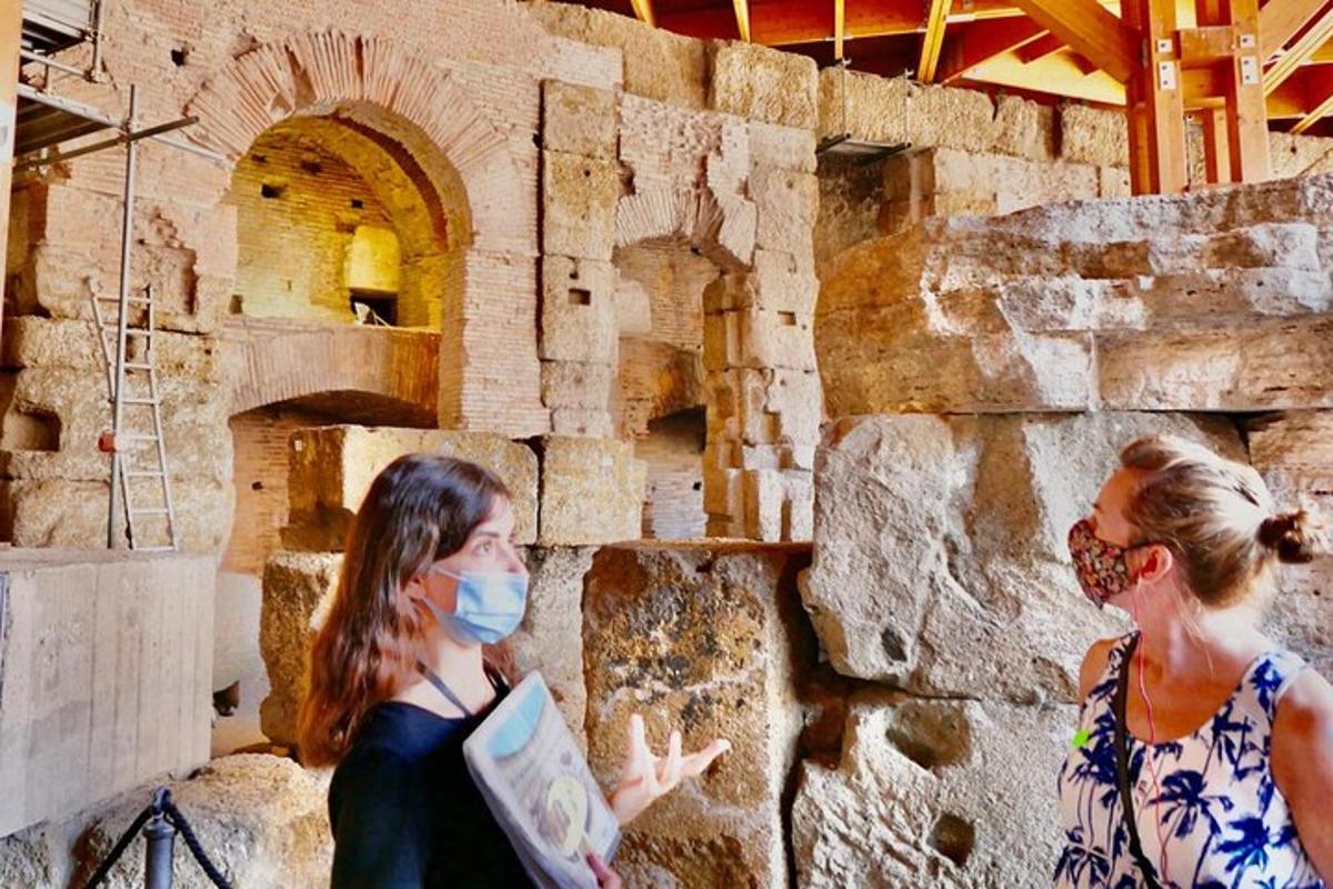 two women wearing masks standing next to a stone wall