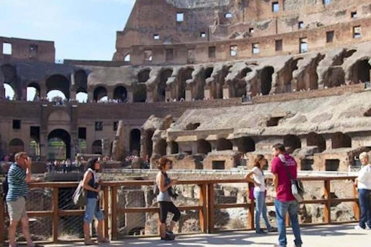 a group of people walking around the coliseum