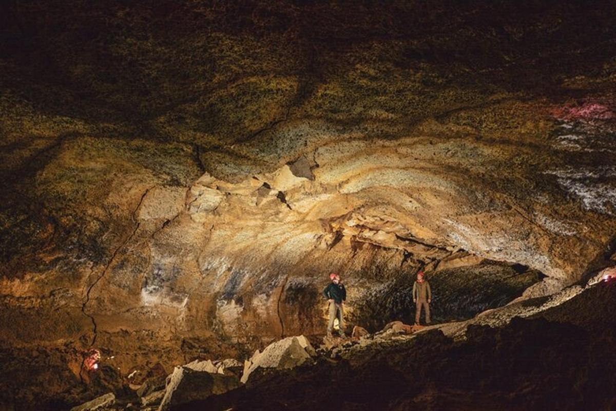 two people standing in front of a cave