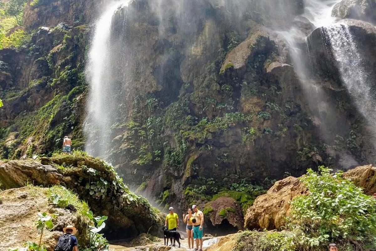 a group of people standing in front of a waterfall