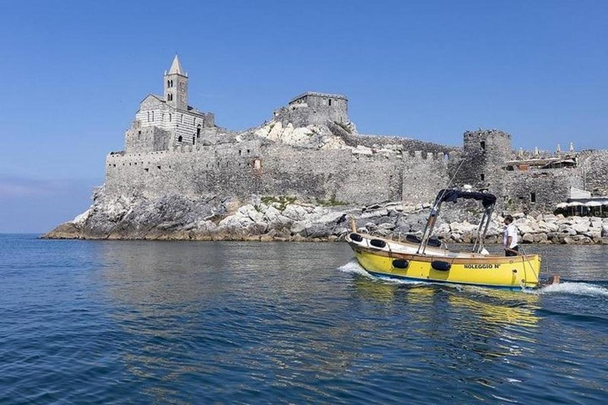 a yellow boat in the water in front of a castle