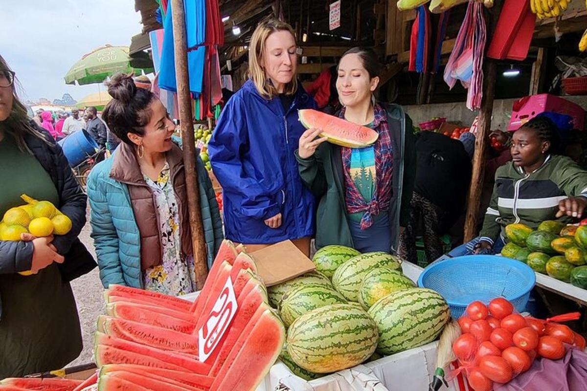 a group of women standing around a market with watermelon