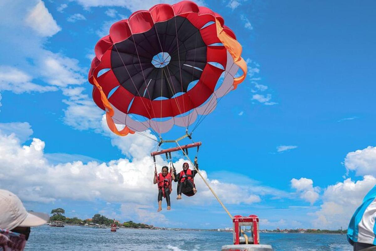 two people are riding a parachute over the water