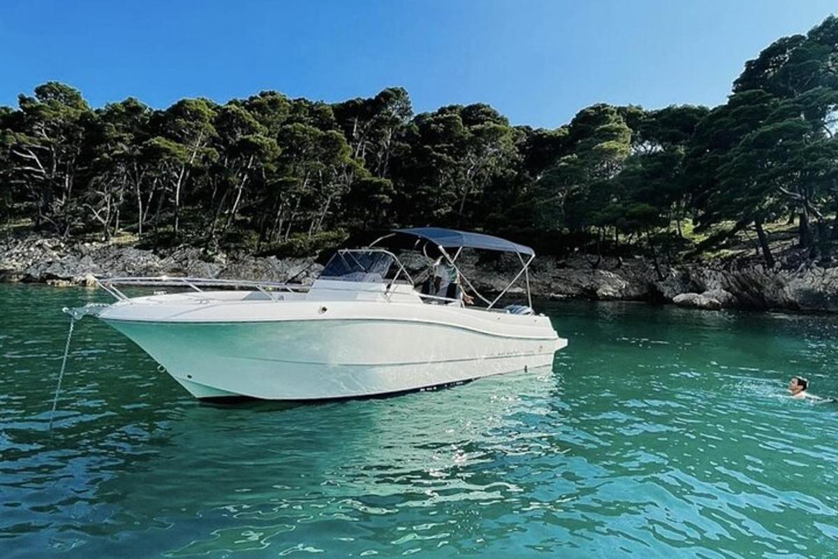 una barca bianca nell'acqua con una persona che nuota