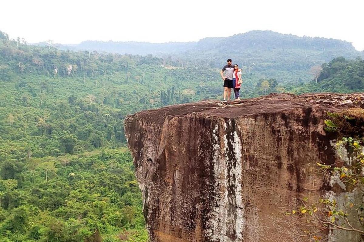 um homem e uma mulher parados na beira de um penhasco