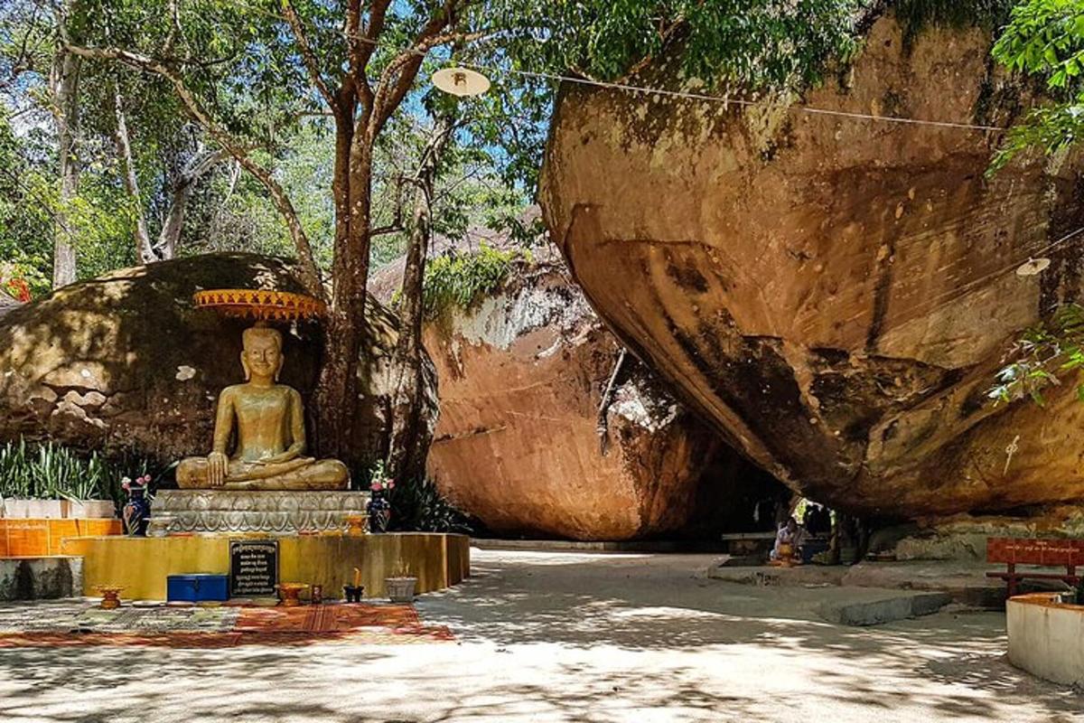 uma estátua de um buda em frente a algumas rochas