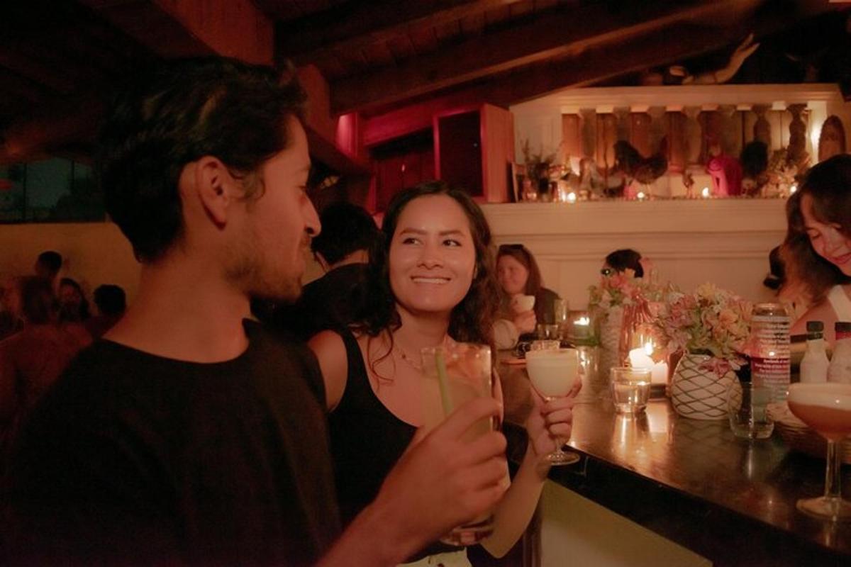 a man and a woman standing at a bar holding drinks
