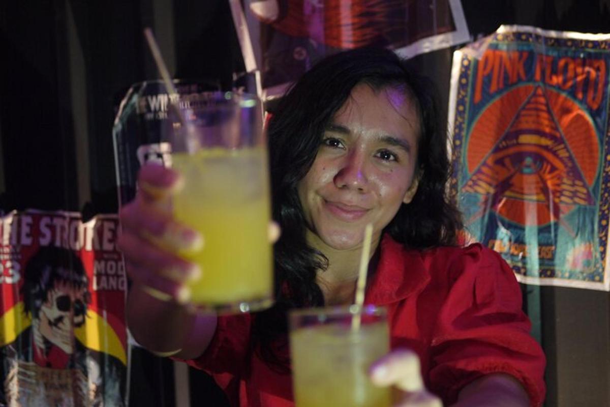 a woman holding up a glass of orange juice