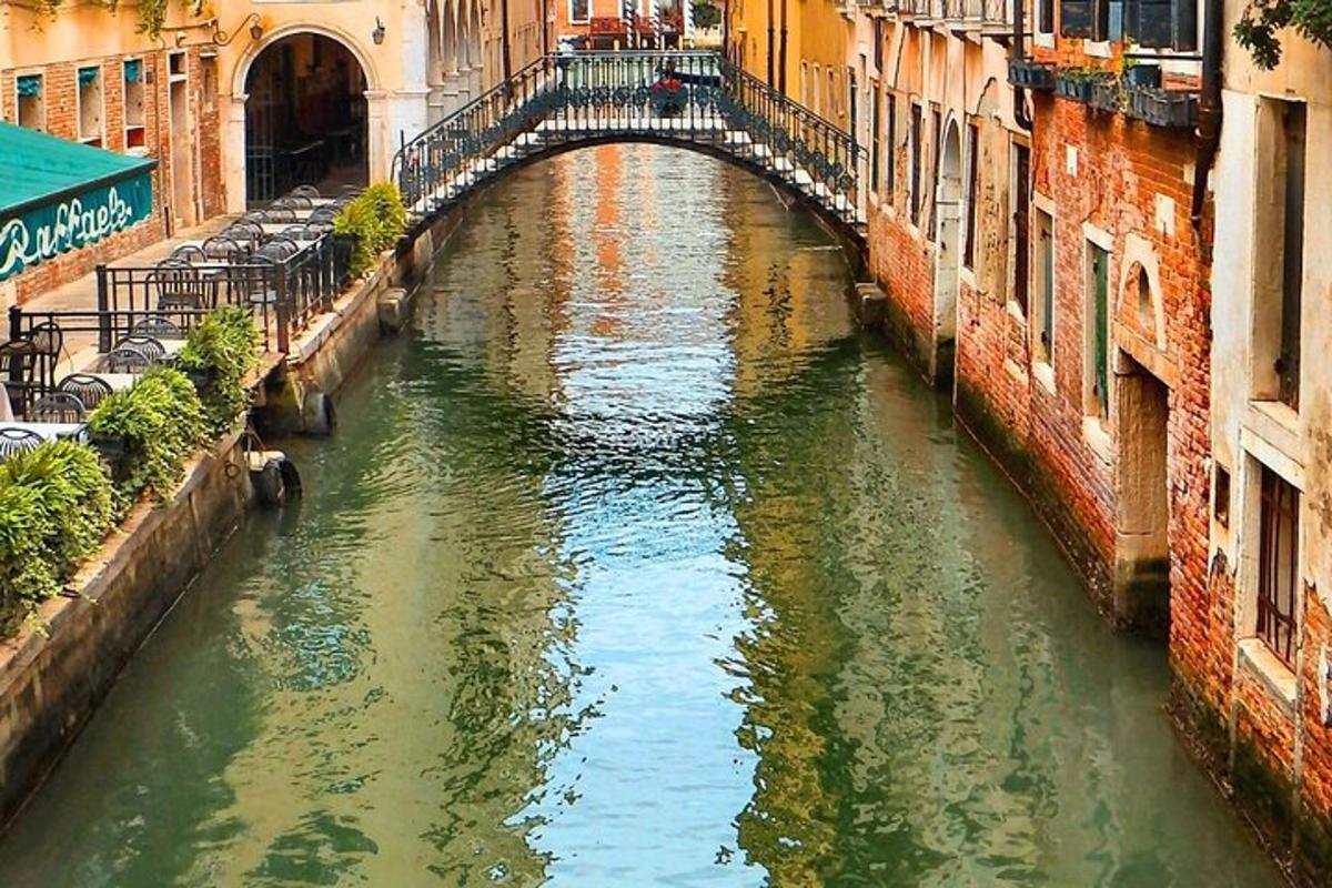 Un pequeño canal con un puente en una ciudad.