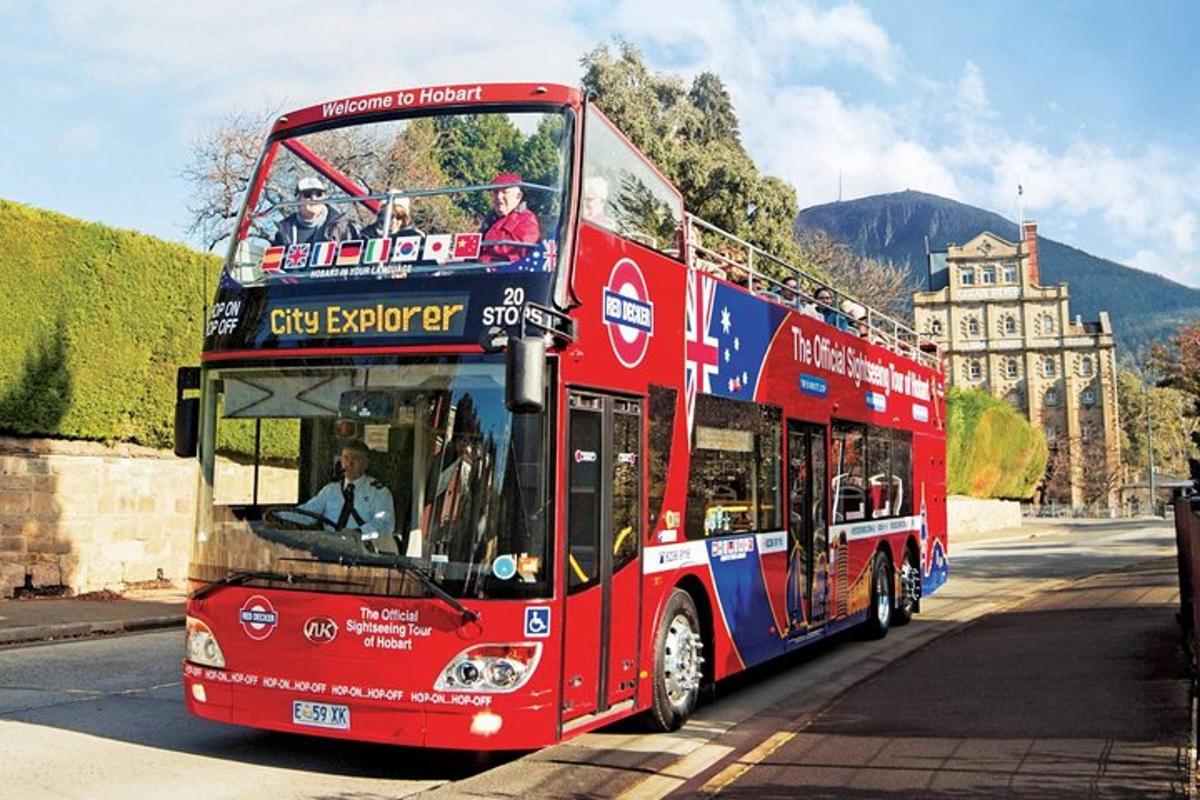 červený dvoupatrový autobus jedoucí po ulici