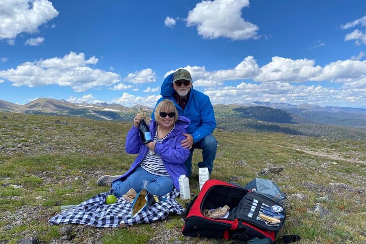 a man and woman sitting on top of a mountain