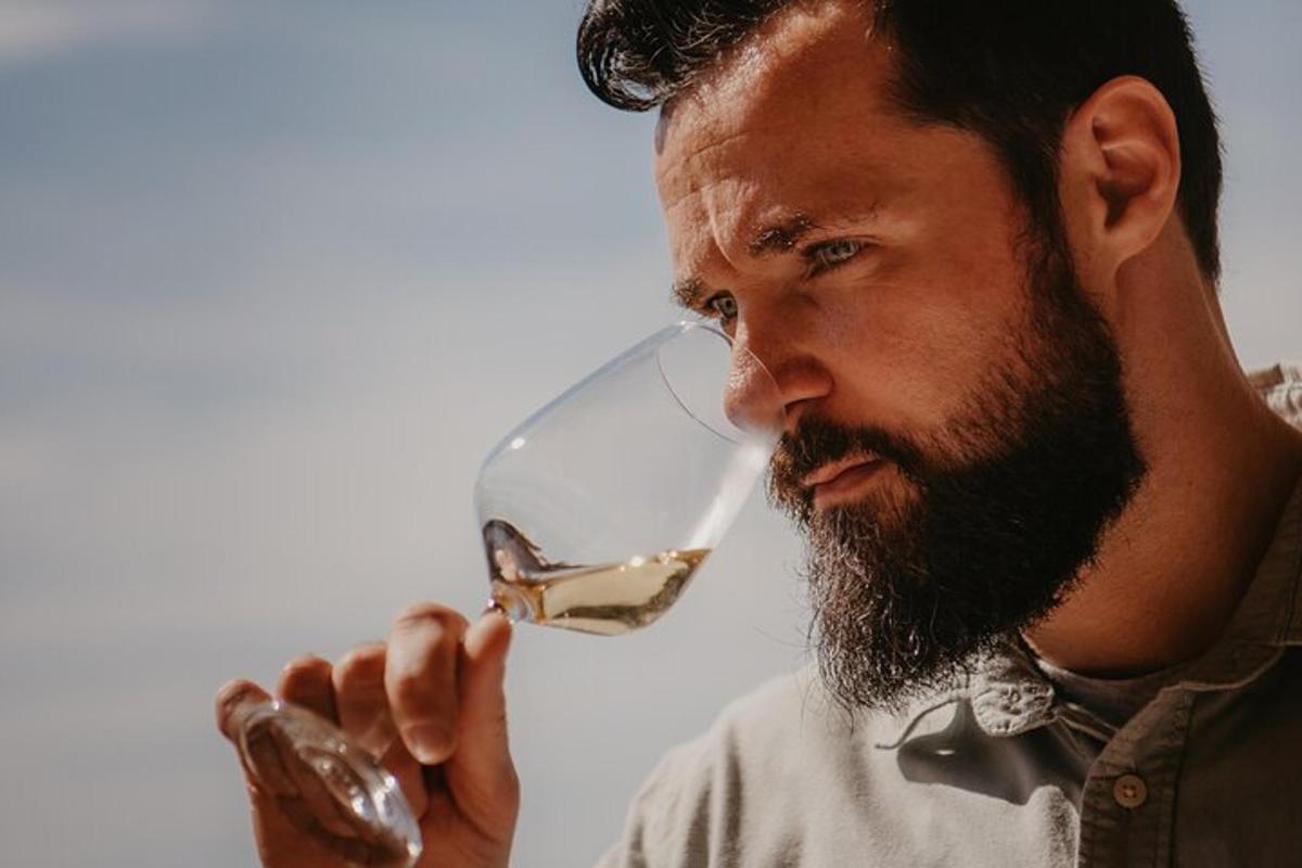 a man drinking a glass of white wine