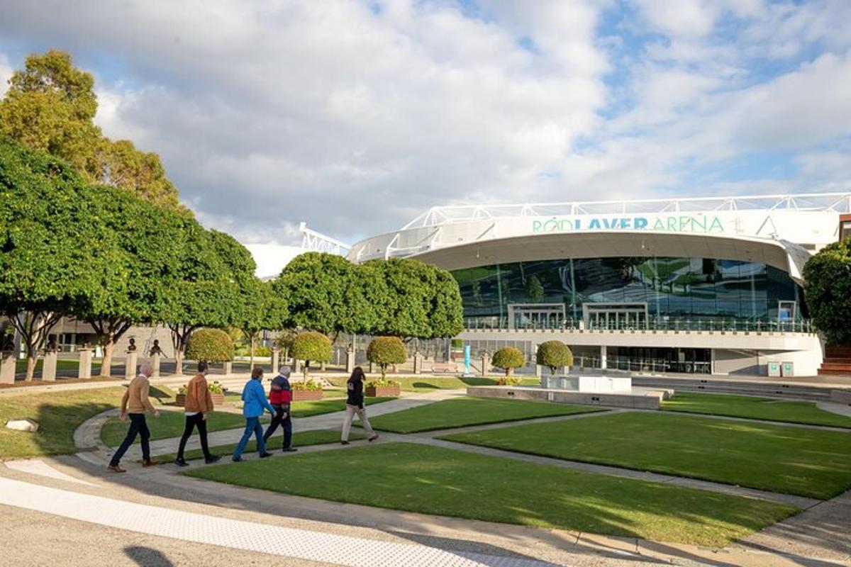 skupina lidí kráčejících před stadionem