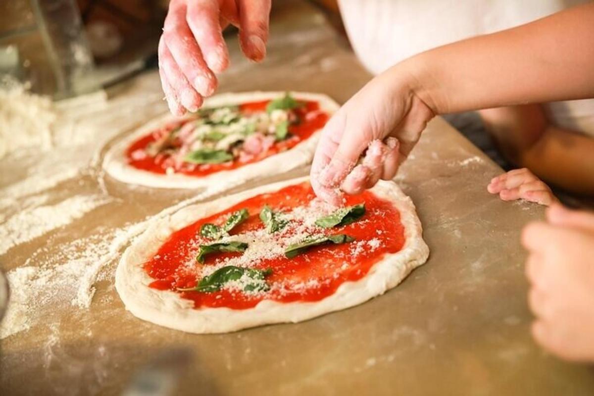 Maður býr til tvær pizzur á borði