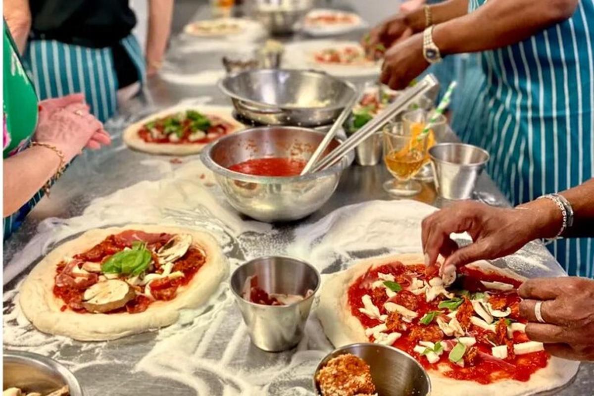 eine Gruppe von Leuten, die auf einem Tisch Pizza machen