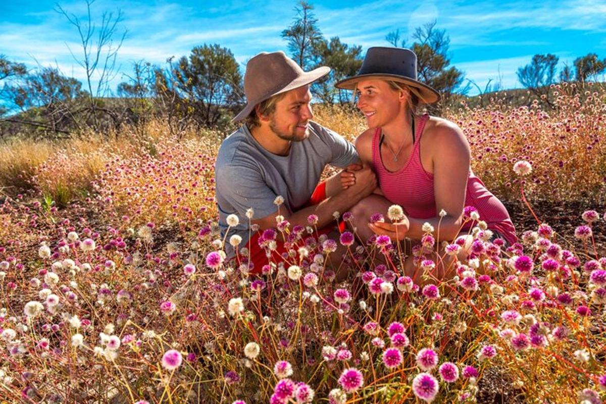 Un hombre y una mujer sentados en un campo de flores.