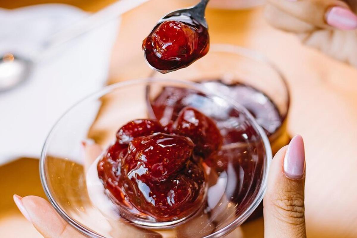 egy személy, aki lekváros kanállal tart egy üvegtálon