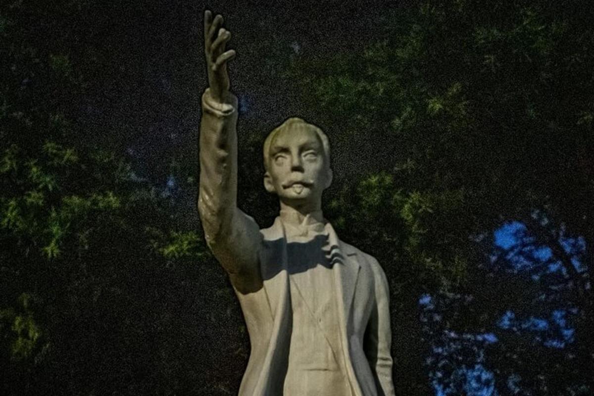 una estatua de un hombre con la mano en el aire