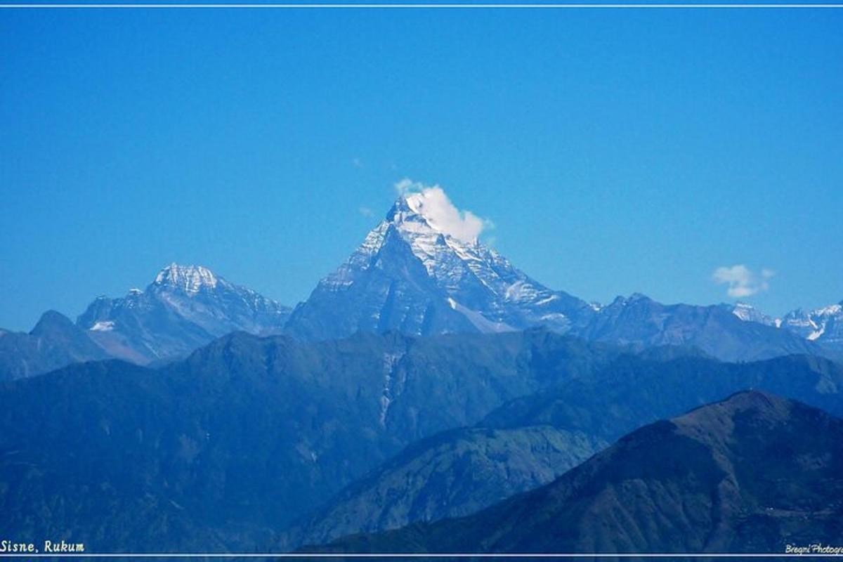a snow capped mountain in the middle of a mountain range