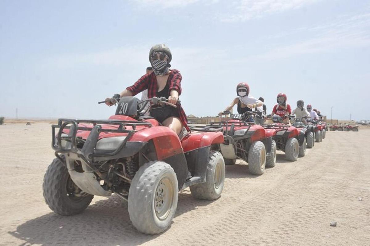 un grup de persones conduint quads al desert