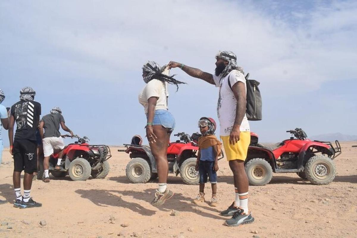 un grup de persones dempeus davant de vehicles tot terreny al desert