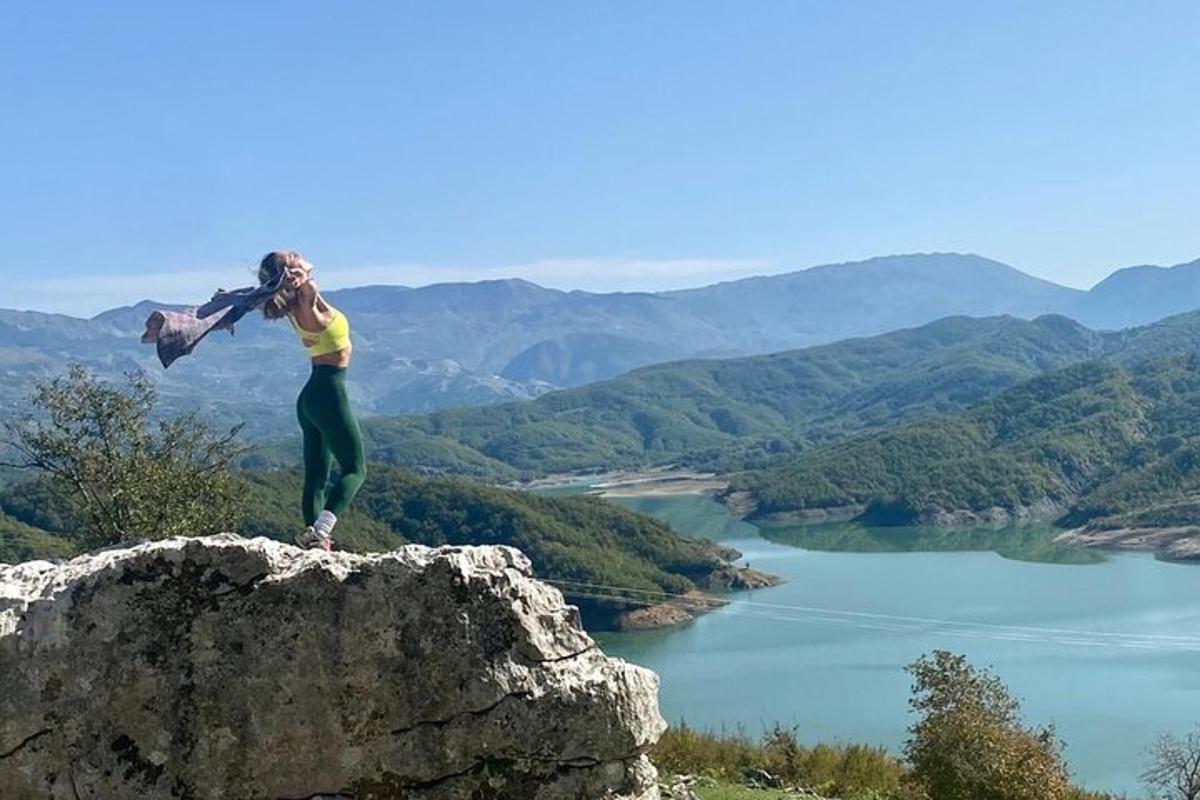 Una mujer está parada encima de una roca