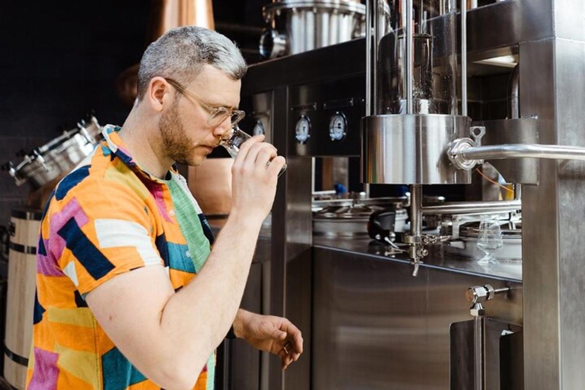 a man standing in a kitchen drinking from a bottle