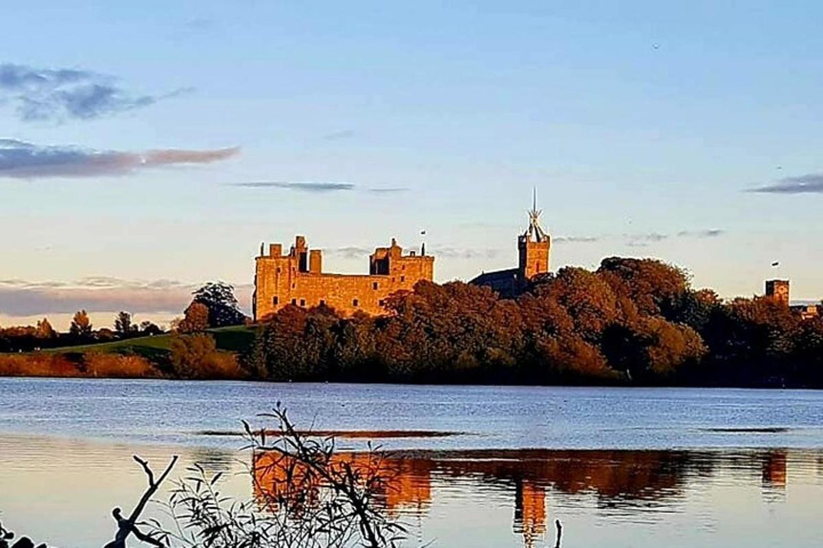 un castello situato su una collina accanto a uno specchio d'acqua