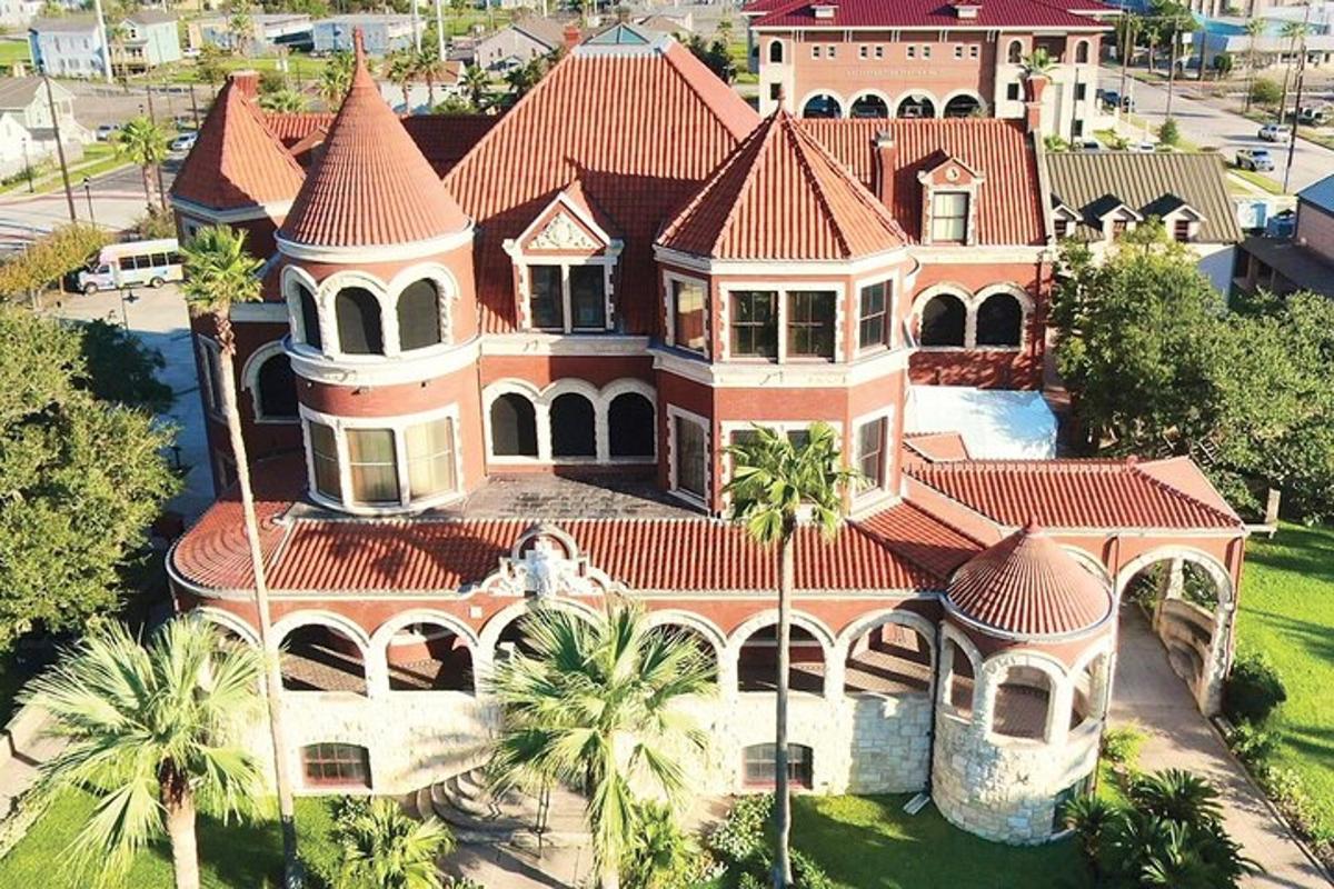 an aerial view of a large house with palm trees