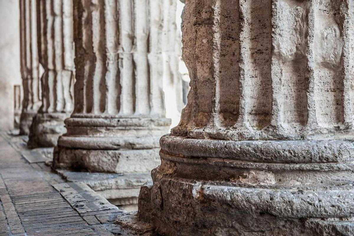 uma fileira de colunas na lateral de um edifício